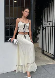 Sweet two-piece set with ruffled bow camisole and pleated maxi skirt in cream white.