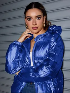 Detail view of a shiny blue oversized hooded puffer jacket with a metallic finish