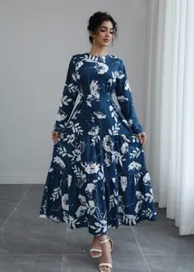 Detailed view of a navy blue long-sleeved floral dress with elegant waist tie and layered hem.