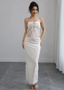 Elegant white lace two-piece set featuring a strapless tie-front tube top and matching maxi skirt.
