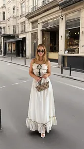 Full-body street style view showing the fit of the white bow camisole and ruffled skirt set