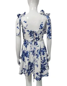 Detailed rear view of a white and blue floral holiday dress with lace-up back and tie-shoulder