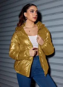 Detail shot of a shiny gold metallic puffer jacket for winter, worn in a street style look.