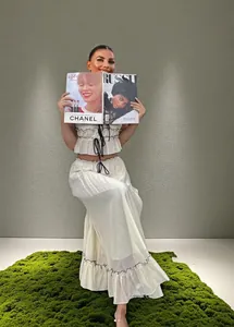 Two-piece white ruffled crop top and long skirt set with a magazine on model