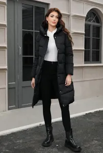 Full-length view of a woman in a long black hooded puffer coat in a street setting