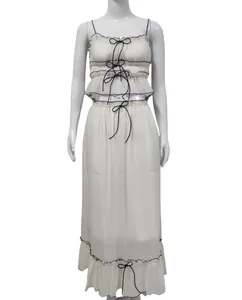 Detailed look of white two-piece chiffon set with black bow accents and ruffles