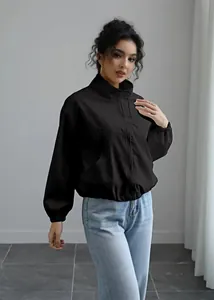 Elegant woman wearing black stand-collar windbreaker jacket in minimalist studio