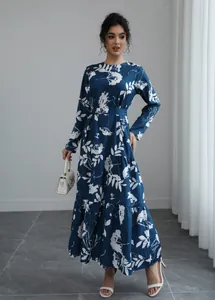 Elegant blue floral maxi dress with long sleeves and defined waist in indoor setting