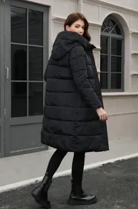 Long black winter hooded puffer jacket for women shown from a stylish side-back view.