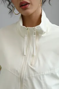Close-up detail of white stand-collar windbreaker jacket featuring double zipper design