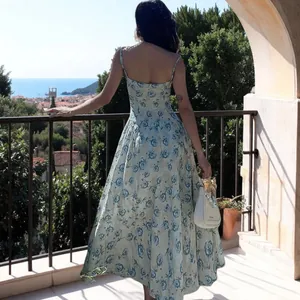 Rückenansicht eines eleganten Blumen-Maxikleids auf einem schönen mediterranen Balkon