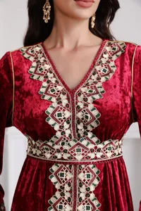 Close-up of intricate embroidery on red crushed velvet V-neck long-sleeve dress.