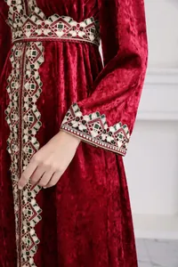 Detail of exquisite embroidery on red velvet long-sleeved maxi dress sleeve