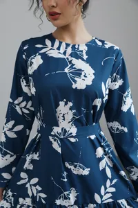 Detail view of a blue long-sleeve floral midi dress featuring a cinched waist and round neck.