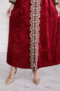 Detailed view of a burgundy velvet long dress with intricate gold and green embroidery