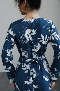 Back view of a blue French style floral print midi dress with waist tie detail.