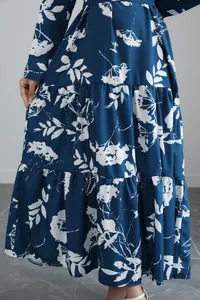 Detailed macro shot of a blue long-sleeved floral midi dress with tiered skirt and French print