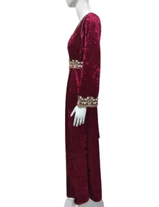 Side view of maroon crushed velvet maxi dress with gold embroidered details