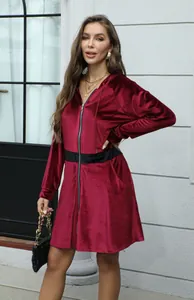 Foto de moda de una mujer con un vestido de terciopelo burdeos con capucha y cremallera