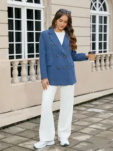 Femme élégante portant un blazer en velours côtelé bleu à double boutonnage et pantalon blanc