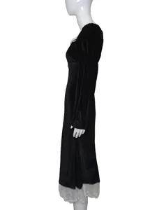 Vista laterale di un elegante vestito in velluto nero con pizzo su manichino bianco