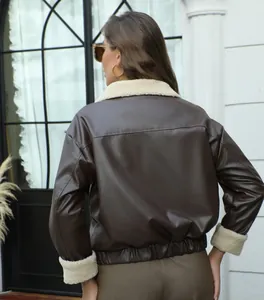 Vista trasera de la chaqueta de cuero marrón con cuello y puños de borreguito crema.