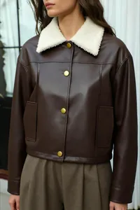 Detalle de chaqueta vintage de piel sintética marrón con cuello de borrego blanco