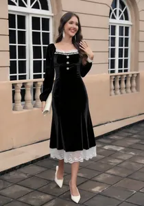 Vista dettagliata dell'elegante abito in velluto nero con pizzo bianco e bottoni