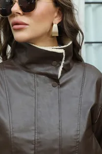 Vista detallada del cuello de la chaqueta de cuero marrón con forro de sherpa crema.
