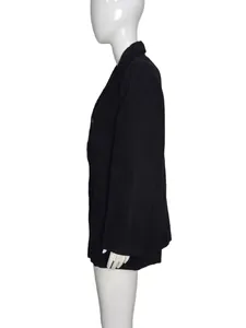Détail de profil d'un blazer noir en velours côtelé avec coupe ample et tissu texturé