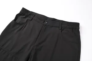 Detailed macro view of black outdoor men's shorts with elastic waistband and button.