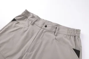 Macro detail of the elastic waistband and pocket stitching on grey techwear cargo pants