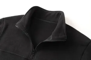 Dettaglio ravvicinato di una felpa da uomo in pile nero di qualità con collo alto.