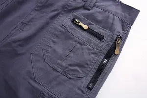 Primer plano detallado de las cremalleras y bolsillos de unos pantalones cargo grises