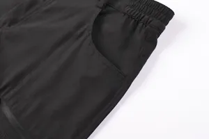 Detail view of black outdoor sports shorts showing elastic waistband and side pocket