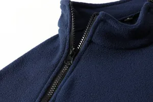 Dettaglio ravvicinato di una giacca in pile blu scuro con cerniera e colletto morbido