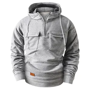 Detailed view of a grey half-zip hoodie with multi-pocket design and leather patch.