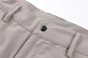 Close-up detail of grey mens outdoor cargo shorts waistband featuring black button and stitching