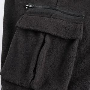 Close-up detail of black polar fleece joggers featuring a cargo pocket with zipper.