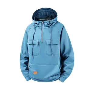 Detailed view of blue men's hoodie with half-zip and multiple utility pockets