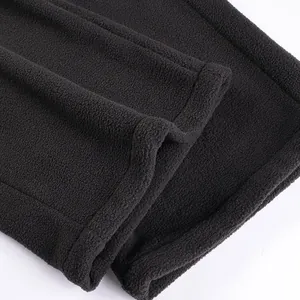 Detailed view of the soft polar fleece texture and hem of black men's trousers