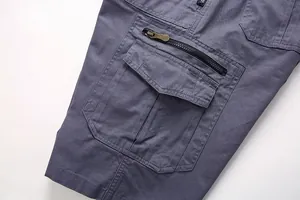 Detalle de cerca del diseño multibolsillos en pantalones cortos cargo grises para hombre