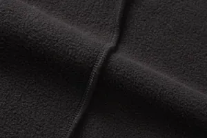 Dettaglio ravvicinato del tessuto in pile nero con texture morbida e cuciture