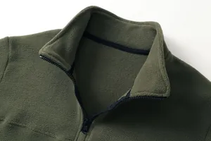 Dettaglio ravvicinato di un pullover in pile verde oliva con zip e trama morbida del colletto