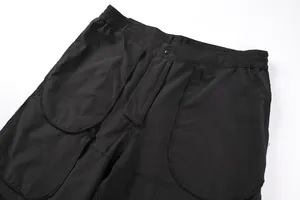 Close-up detail of men's black outdoor shorts featuring elastic waist and large pockets