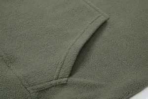 Detailed macro shot of olive green fleece hoodie showing soft texture and pocket seams