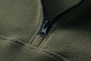 Dettaglio della cerniera e della calda trama in pile di una felpa verde militare da uomo.