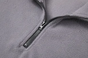 Detailed macro view showing the high-quality metal zipper on a grey fleece sweatshirt