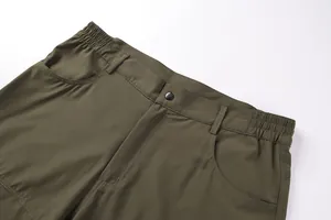 Macro detail view of men's olive green outdoor shorts with elastic waist and button
