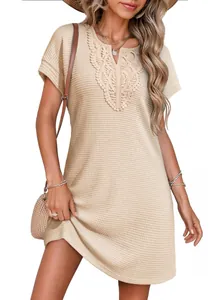 Close-up of the intricate lace V-neck and waffle-knit texture of the apricot dress